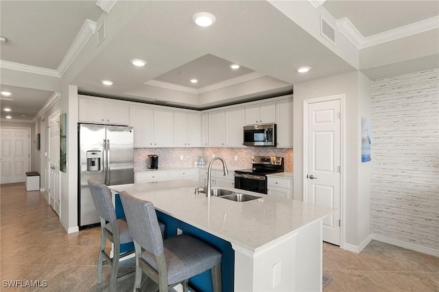 10720 Palazzo Way Unit 405, Fort Myers, FL 33913 - kitchen featuring stainless steel appliances, ornamental molding, white cabinets, a kitchen breakfast bar, and a center island with sink