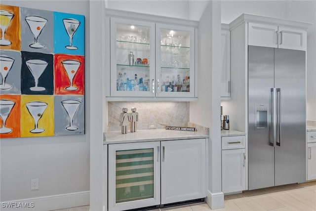 3159 Heather Glen Ct, Naples, FL 34114 - indoor dry bar featuring stainless steel built in refrigerator, wine cooler, and tasteful backsplash