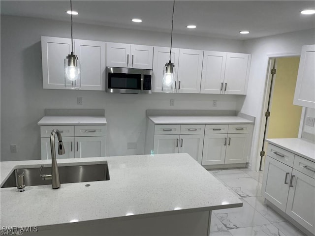 3220 Jeffcott St, Fort Myers, FL 33916 - kitchen with stainless steel microwave, light marble finish flooring, recessed lighting, light stone counters, and pendant lighting