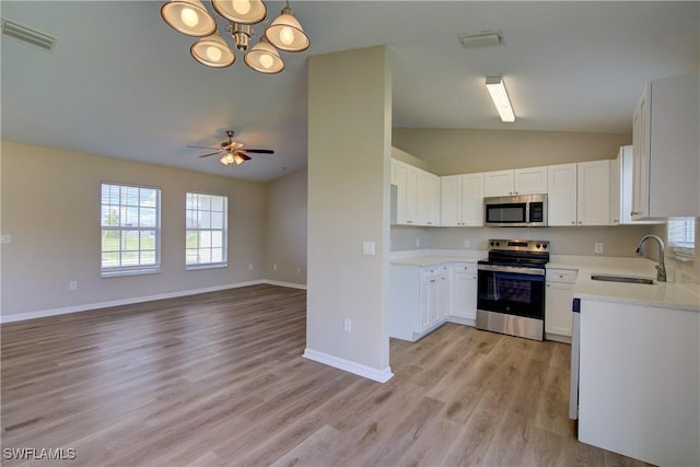 109 NE 11th St, Cape Coral, FL 33909 - kitchen with appliances with stainless steel finishes, lofted ceiling, light countertops, white cabinets, and light wood-style floors