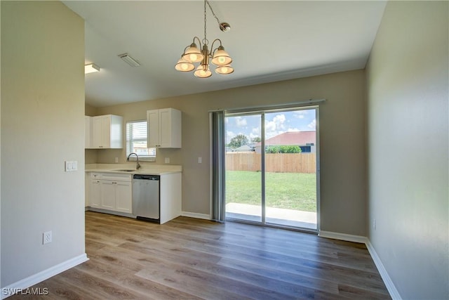 109 NE 11th St, Cape Coral, FL 33909 - kitchen with stainless steel dishwasher, white cabinetry, a chandelier, light countertops, and wood finished floors