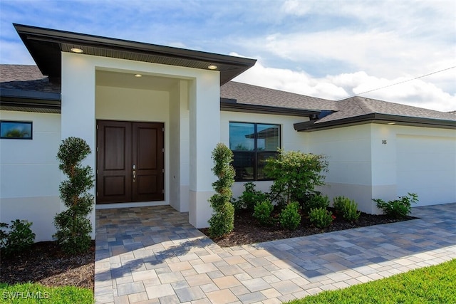 5415 Agualinda Blvd, Cape Coral, FL 33914 - property entrance featuring an attached garage, stucco siding, and a shingled roof