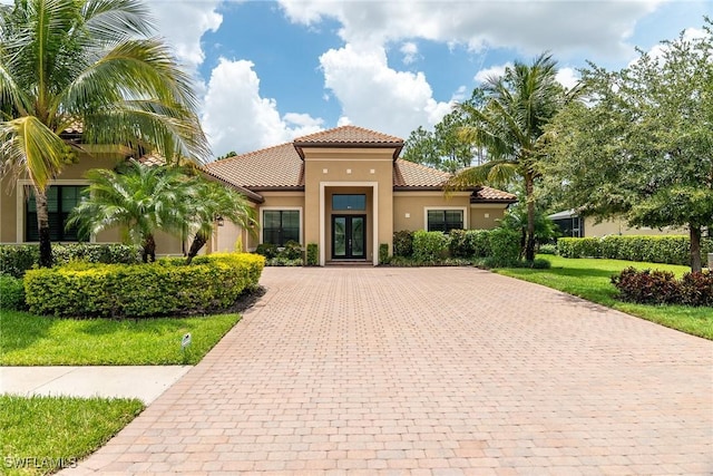 1387 Mockingbird Dr, Naples, FL 34120 - mediterranean / spanish-style home with a tile roof, driveway, stucco siding, and french doors