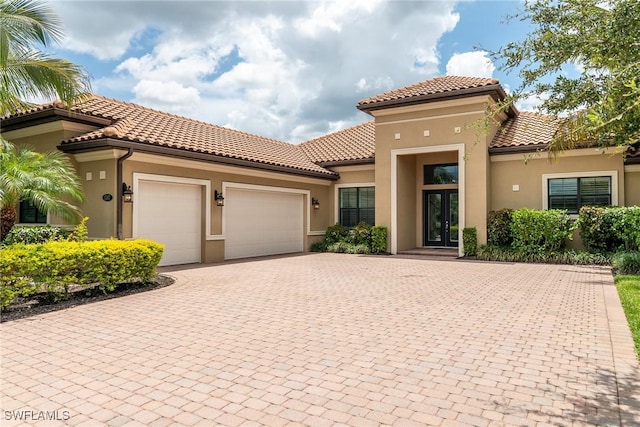1387 Mockingbird Dr, Naples, FL 34120 - mediterranean / spanish house featuring french doors, a garage, driveway, and stucco siding