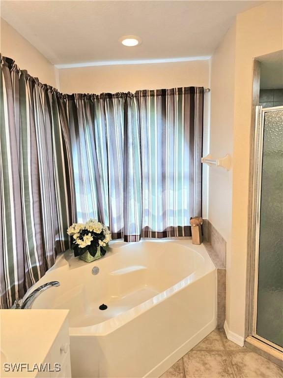 619 Charles Sise St, Lehigh Acres, FL 33974 - full bathroom with a garden tub, a stall shower, vanity, and tile patterned floors