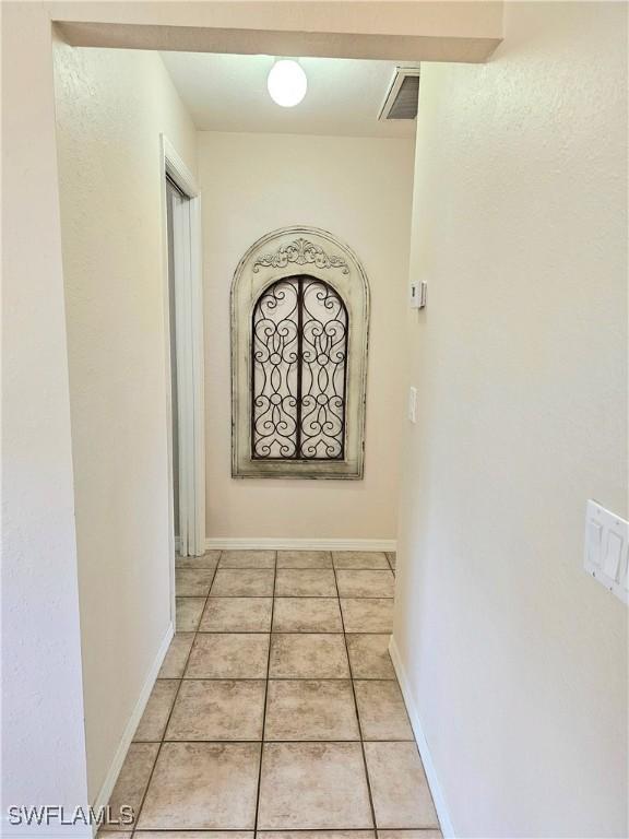 619 Charles Sise St, Lehigh Acres, FL 33974 - hall with light tile patterned floors and baseboards