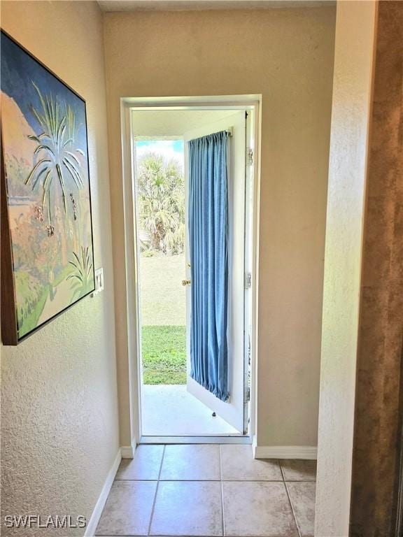 619 Charles Sise St, Lehigh Acres, FL 33974 - doorway to outside featuring baseboards and tile patterned flooring