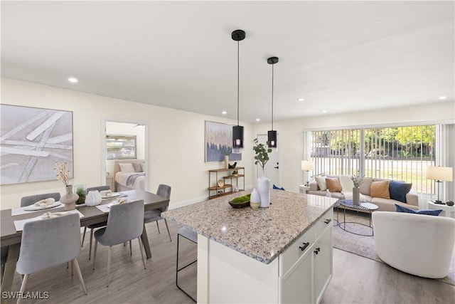 207 Leeland Heights Blvd W, Lehigh Acres, FL 33936 - kitchen with light wood-style floors, a kitchen island, open floor plan, white cabinets, and recessed lighting