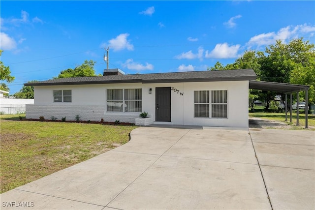 207 Leeland Heights Blvd W, Lehigh Acres, FL 33936 - ranch-style house with driveway, a front yard, stucco siding, and a carport