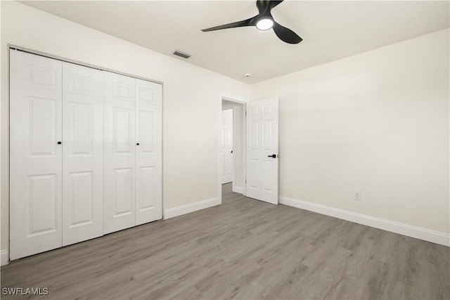 207 Leeland Heights Blvd W, Lehigh Acres, FL 33936 - unfurnished bedroom with wood finished floors, a closet, and a ceiling fan