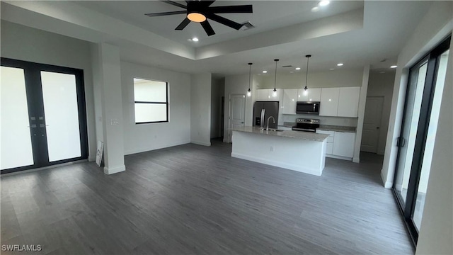 933 Gleason St, Lehigh Acres, FL 33974 - kitchen with appliances with stainless steel finishes, white cabinetry, open floor plan, wood finished floors, and recessed lighting