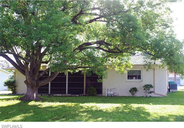 2119 Pellam Blvd, Port Charlotte, FL 33948 - view of property hidden behind natural elements with stucco siding, a front yard, and a sunroom