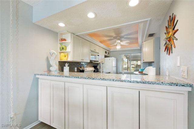 4549 SE 5th Pl Unit 109, Cape Coral, FL 33904 - kitchen featuring white appliances, open shelves, a tray ceiling, a peninsula, and ceiling fan