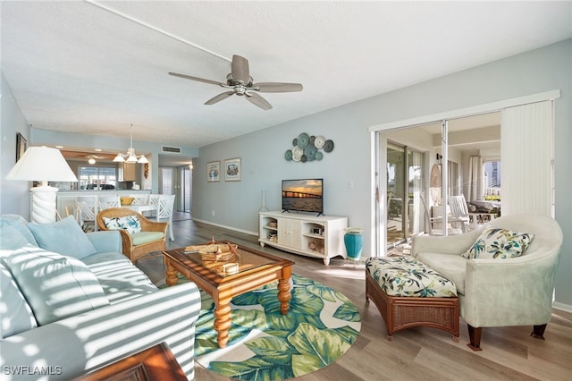 4549 SE 5th Pl Unit 109, Cape Coral, FL 33904 - living room with a chandelier, a ceiling fan, wood finished floors, and a textured ceiling