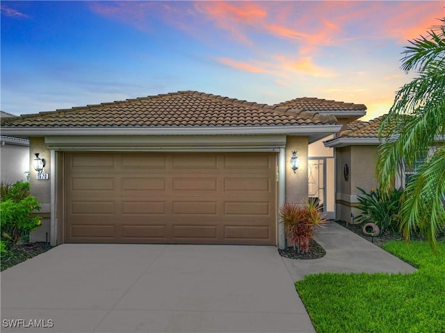 1670 Palo Duro Blvd, North Fort Myers, FL 33917 - view of front of property featuring concrete driveway, stucco siding, an attached garage, and a tile roof