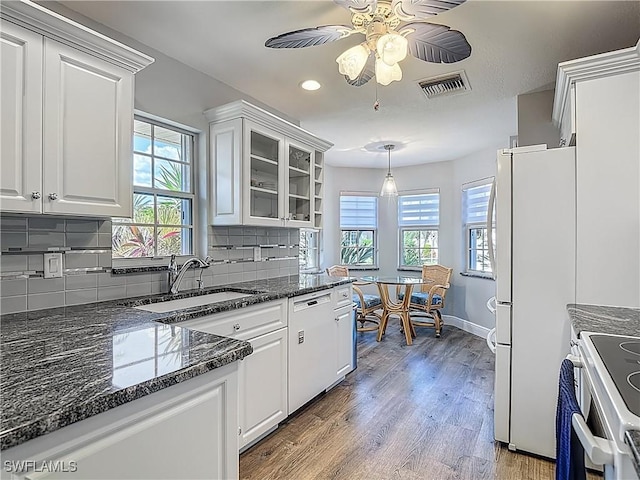 1670 Palo Duro Blvd, North Fort Myers, FL 33917 - kitchen with white appliances, white cabinetry, decorative backsplash, light wood-style floors, and recessed lighting