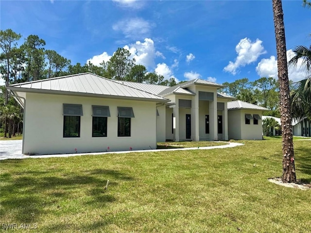 5174 Sycamore Dr, Naples, FL 34119 - view of front of property featuring a standing seam roof, stucco siding, a front yard, and a metal roof
