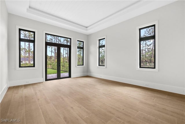 5174 Sycamore Dr, Naples, FL 34119 - empty room with a raised ceiling, light wood-style floors, and french doors
