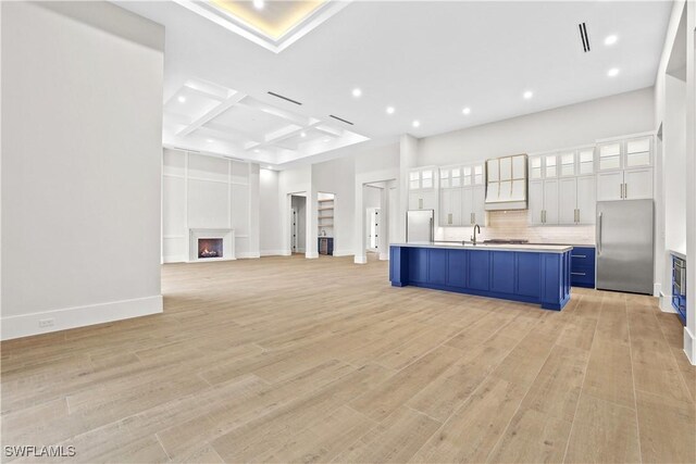 5174 Sycamore Dr, Naples, FL 34119 - unfurnished living room with coffered ceiling, recessed lighting, light wood-style flooring, a lit fireplace, and beamed ceiling