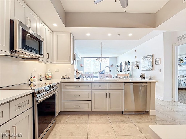 3000 Oasis Grand Blvd Unit 1203, Fort Myers, FL 33916 - kitchen with appliances with stainless steel finishes, a peninsula, recessed lighting, ceiling fan, and light countertops