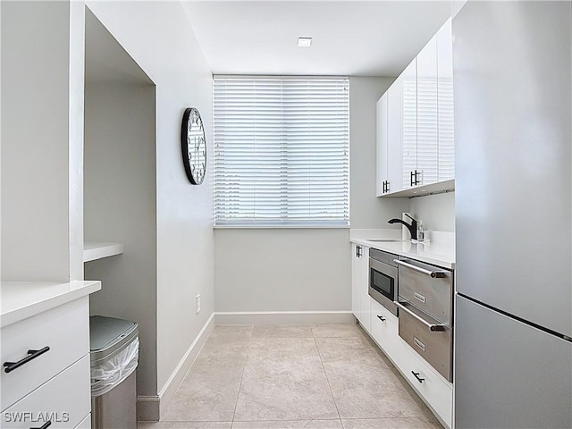 3000 Oasis Grand Blvd Unit 1203, Fort Myers, FL 33916 - kitchen featuring white cabinets, fridge, light countertops, modern cabinets, and stainless steel microwave