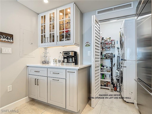 3000 Oasis Grand Blvd Unit 1203, Fort Myers, FL 33916 - bar area featuring stacked washer / dryer, stainless steel built in refrigerator, recessed lighting, light tile patterned floors, and electric panel