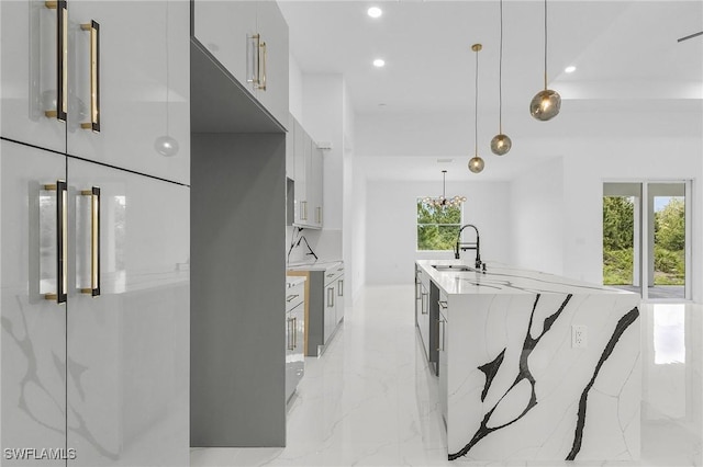 3805 E 16th St, Lehigh Acres, FL 33972 - kitchen with fridge, modern cabinets, recessed lighting, light marble finish flooring, and decorative light fixtures