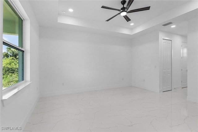 3805 E 16th St, Lehigh Acres, FL 33972 - empty room with marble finish flooring, ceiling fan, a raised ceiling, and recessed lighting