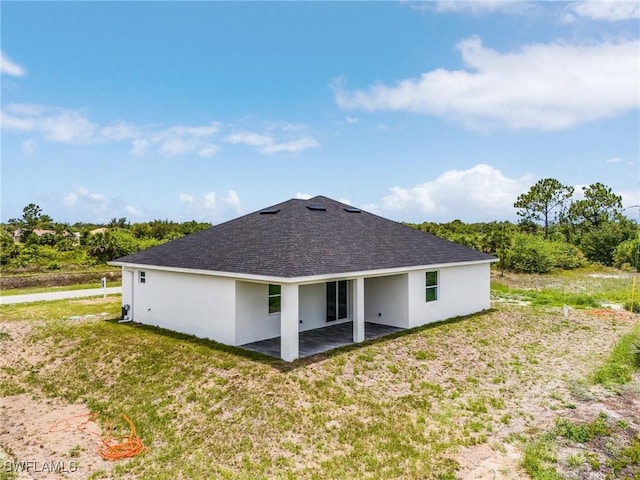 3805 E 16th St, Lehigh Acres, FL 33972 - rear view of house featuring a patio area, stucco siding, a lawn, and a shingled roof