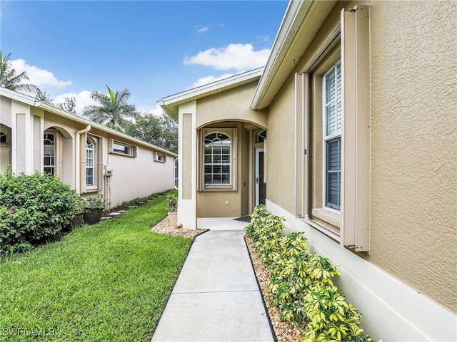 8612 Ibis Cove Cir, Naples, FL 34119 - property entrance with stucco siding and a yard