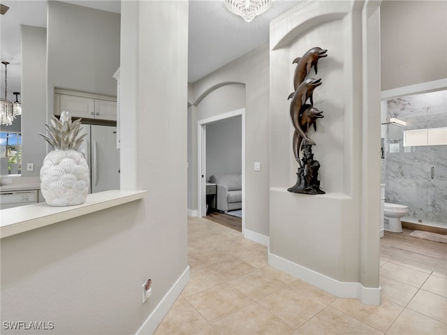 8612 Ibis Cove Cir, Naples, FL 34119 - hallway featuring a chandelier and light tile patterned floors