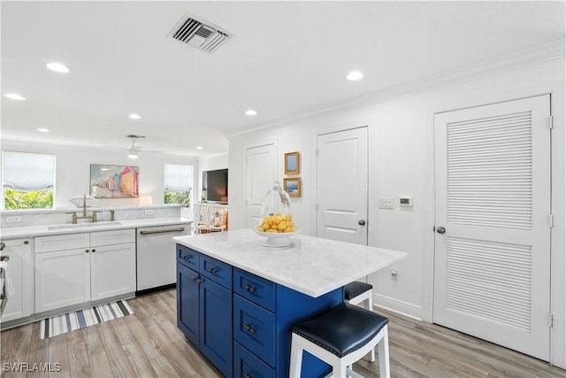 719 Park Ave, Naples, FL 34110 - kitchen featuring white dishwasher, ornamental molding, light wood finished floors, light countertops, and blue cabinets