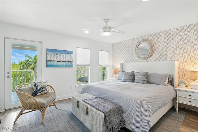 719 Park Ave, Naples, FL 34110 - bedroom with an accent wall, wallpapered walls, access to exterior, multiple windows, and wood finished floors