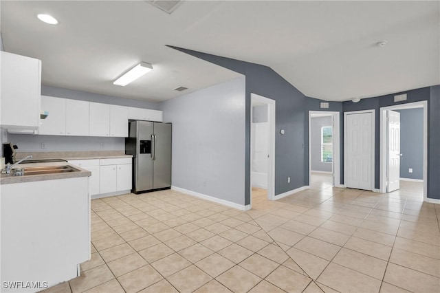 4508/4510 30th St SW, Lehigh Acres, FL 33973 - kitchen featuring stainless steel fridge with ice dispenser, light countertops, lofted ceiling, light tile patterned flooring, and white cabinetry