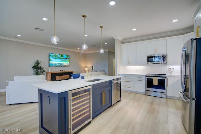 28601 Firenze Way Unit 102, Bonita Springs, FL 34135 - kitchen with beverage cooler, stainless steel appliances, white cabinetry, recessed lighting, and ornamental molding