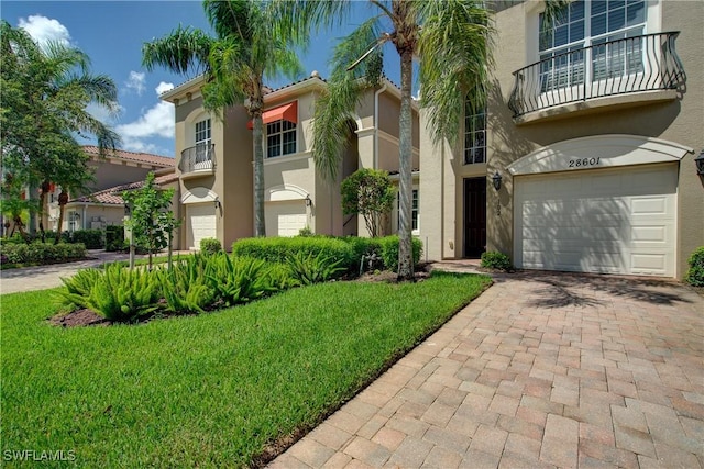 28601 Firenze Way Unit 102, Bonita Springs, FL 34135 - view of front of home featuring stucco siding, an attached garage, decorative driveway, and a front yard