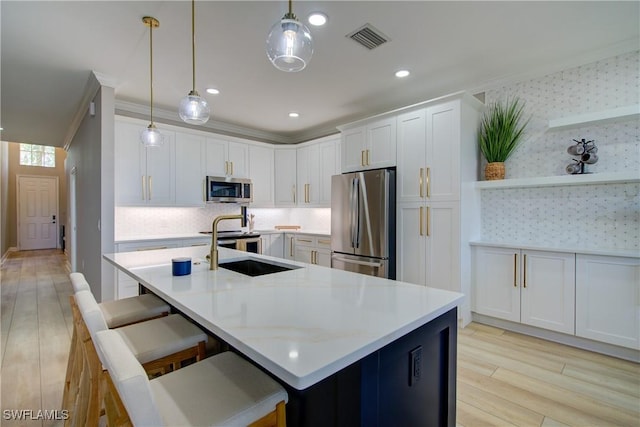 28601 Firenze Way Unit 102, Bonita Springs, FL 34135 - kitchen featuring appliances with stainless steel finishes, light countertops, backsplash, light wood-style floors, and white cabinetry