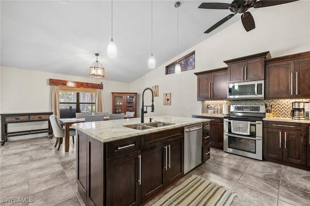 17971 Bermuda Dunes Dr, Fort Myers, FL 33967 - kitchen featuring appliances with stainless steel finishes, tasteful backsplash, decorative light fixtures, an island with sink, and dark brown cabinets