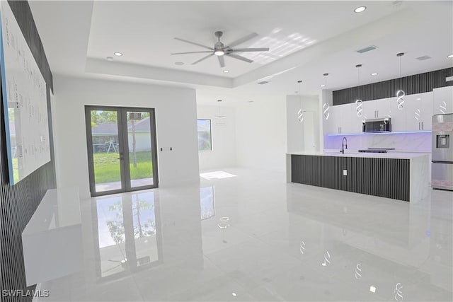 1803 Venice Ave N, Lehigh Acres, FL 33971 - unfurnished living room with a ceiling fan, a raised ceiling, light tile patterned flooring, french doors, and recessed lighting