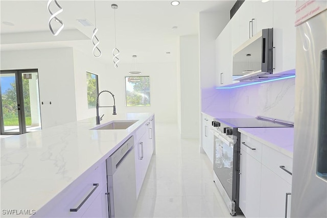 1803 Venice Ave N, Lehigh Acres, FL 33971 - kitchen featuring stainless steel appliances, light tile patterned flooring, hanging light fixtures, white cabinets, and light stone counters