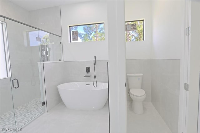 1803 Venice Ave N, Lehigh Acres, FL 33971 - bathroom with a freestanding bath, a stall shower, and tile walls