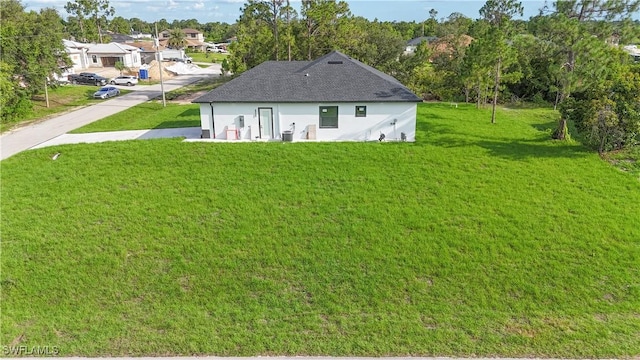 1803 Venice Ave N, Lehigh Acres, FL 33971 - back of house with a lawn, stucco siding, and a shingled roof