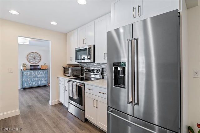 4622 SW 10th Ave, Cape Coral, FL 33914 - kitchen with appliances with stainless steel finishes, white cabinetry, wood finished floors, light countertops, and backsplash