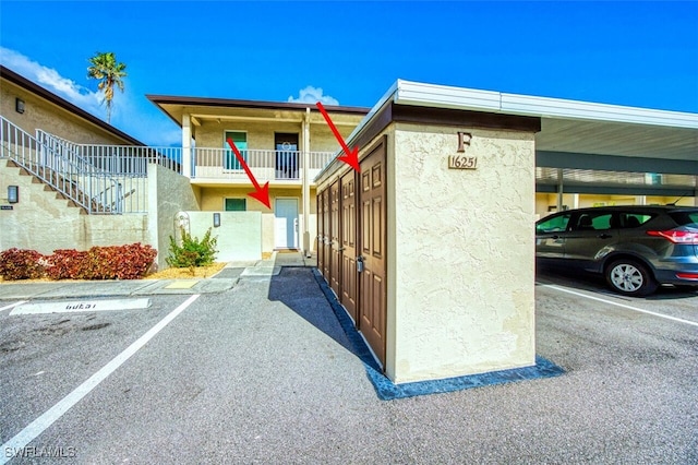 16251 Dublin Cir Unit F101, Fort Myers, FL 33908 - view of building exterior with covered and uncovered parking and stairs