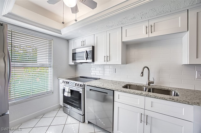 16251 Dublin Cir Unit F101, Fort Myers, FL 33908 - kitchen featuring appliances with stainless steel finishes, decorative backsplash, a ceiling fan, light tile patterned floors, and a tray ceiling
