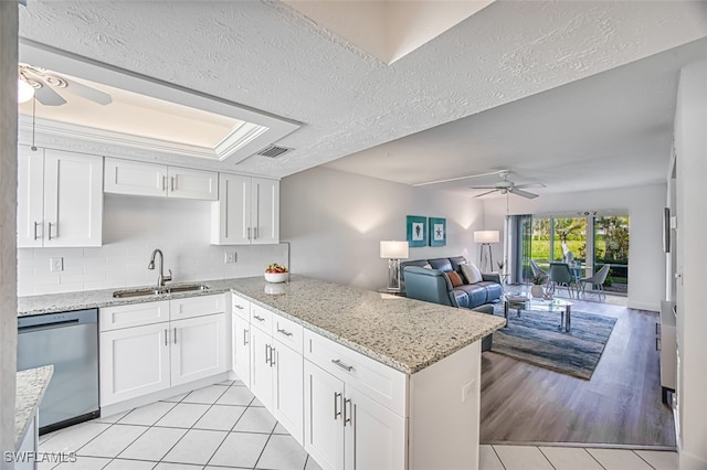16251 Dublin Cir Unit F101, Fort Myers, FL 33908 - kitchen featuring stainless steel dishwasher, ceiling fan, light tile patterned floors, a peninsula, and white cabinets