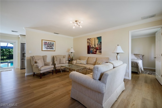 559 Woodruff St, North Fort Myers, FL 33903 - living room featuring light wood-style flooring, crown molding, and a chandelier