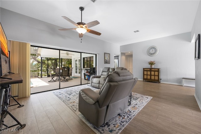 living area featuring a ceiling fan and wood finished floors
