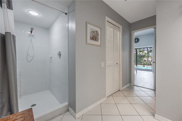 full bathroom with a tile shower and tile patterned flooring