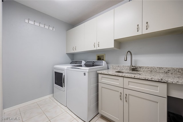 laundry room with washing machine and clothes dryer, cabinet space, and light tile patterned floors